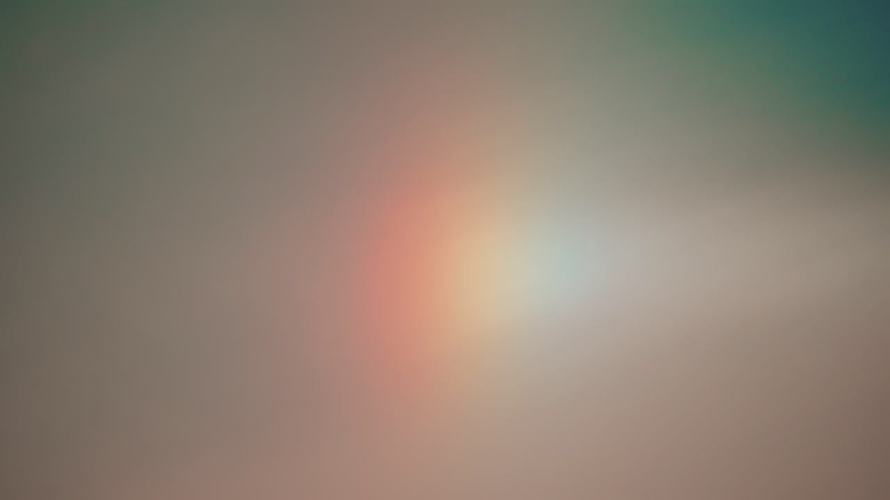 A subtle, soft sky with a faint vertical rainbow or sundog, blending warm and cool tones