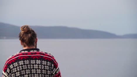 Hombre-Cerca-De-La-Orilla-De-Un-Mar-En-Calma-Durante-El-Día