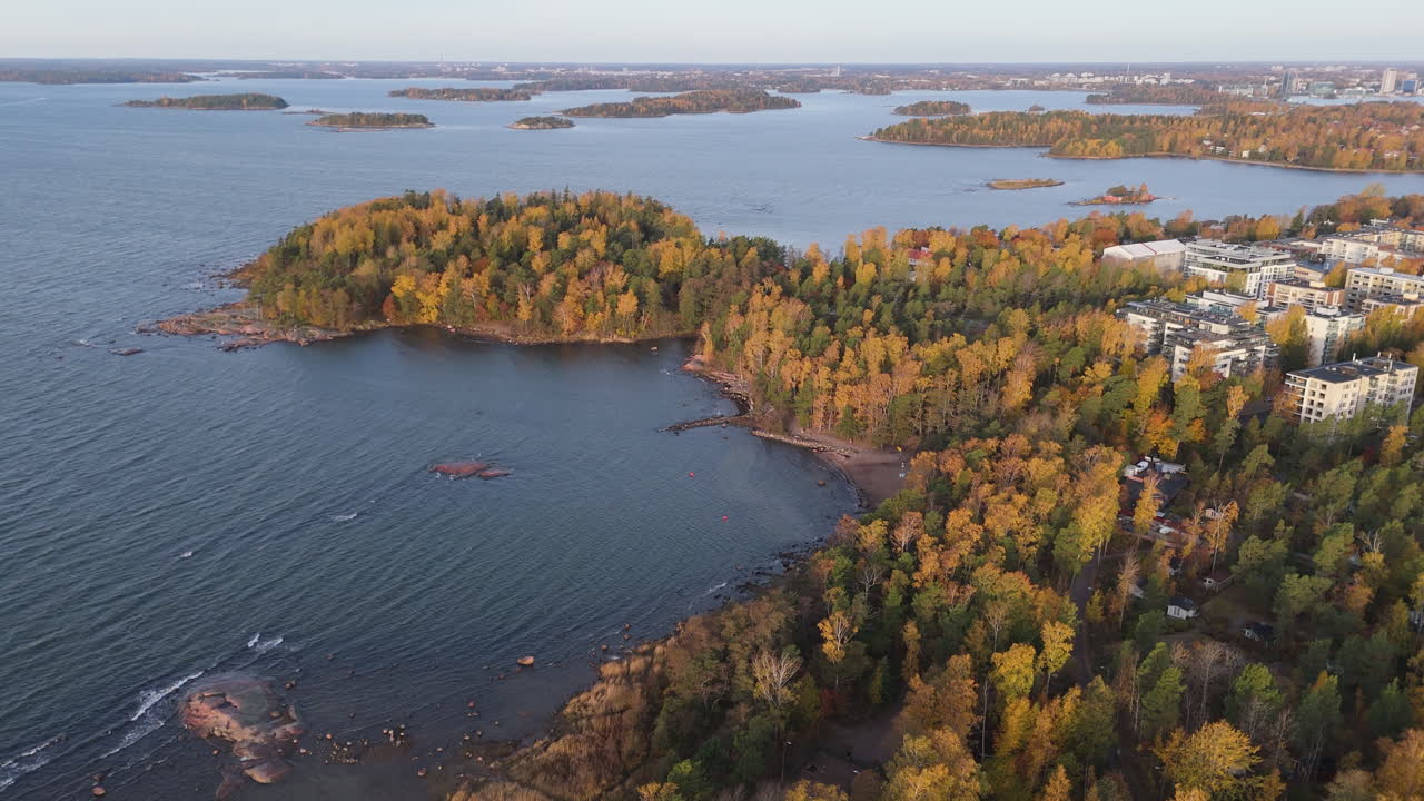 Archipelago of Helsinki with autumn foliage colours on the trees. Aerial view with sea water, forest and buildings