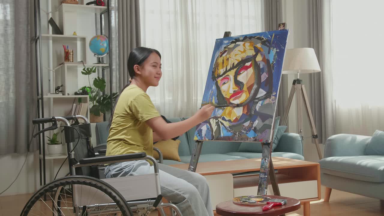 Side View An Asian Artist Girl In Wheelchair Holding Paintbrush Mixed Colour Turn To Cross His Arms And Smile While Painting A Girl On The Canvas
