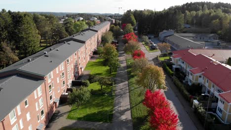 hilera de casas adosadas rodeadas de árboles rojos en otoño, vista aérea