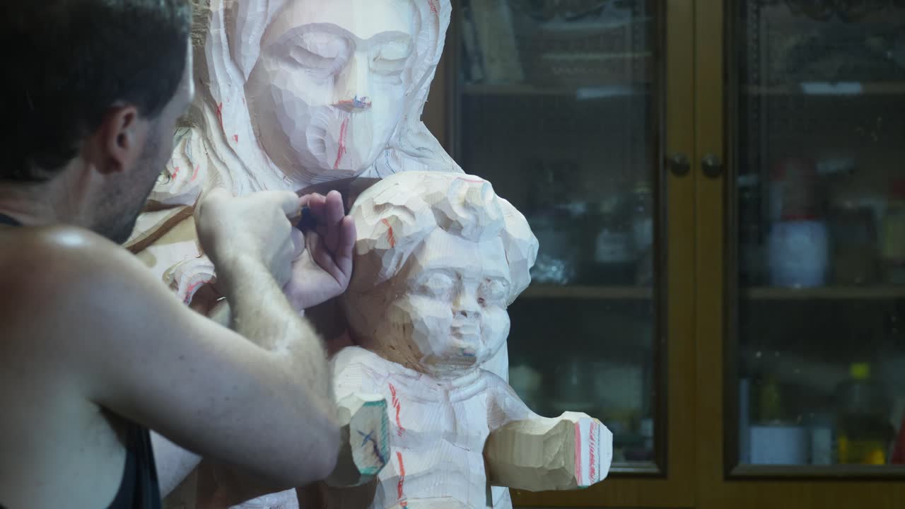 Professional sculptor carefully carving intricate wooden sculpture using traditional chisel technique, capturing detailed craftsmanship with precise slow motion movement