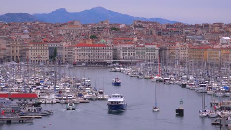 boats enter and exit the harbor in marseilles france