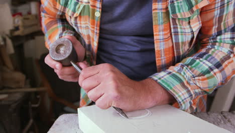 stone mason at work on carving in studio shot on red camera