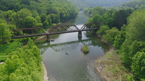 drones aéreos volando sobre el río azul y gente aventurera en kayaks junto a un bosque verde brillante en el centro de pensilvania durante el verano