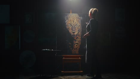 woman artist painting a leopard