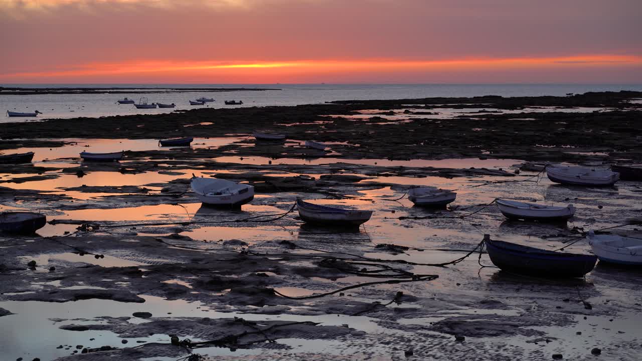 hermosa puesta de sol roja con barcos de pesca en marea baja