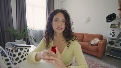 female makeup artist telling about foundation and brush as filming vlog