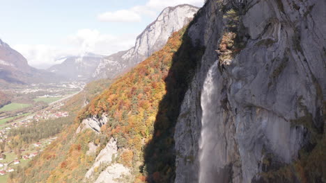 Antena-De-Hermosa-Cascada-Con-Un-Colorido-Bosque-De-Otoño-En-El-Fondo