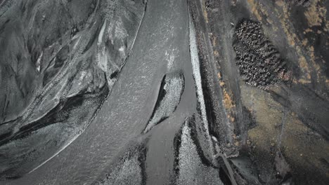 río glacial de lecho aéreo que fluye a través del paisaje volcánico natural negro de arriba hacia abajo