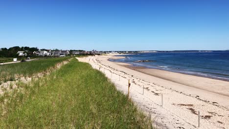 new england beach atmosphere with a panning view of the waters of cape cod bay, the beach and the dunes at town neck beach of sandwich massachusetts near sagamore