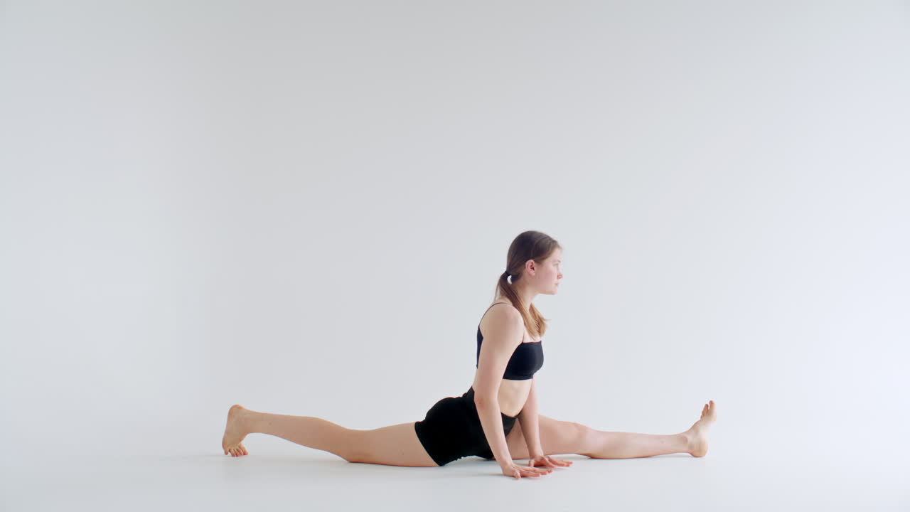 Gadis Melakukan Variasi Pose Split saat Latihan Yoga