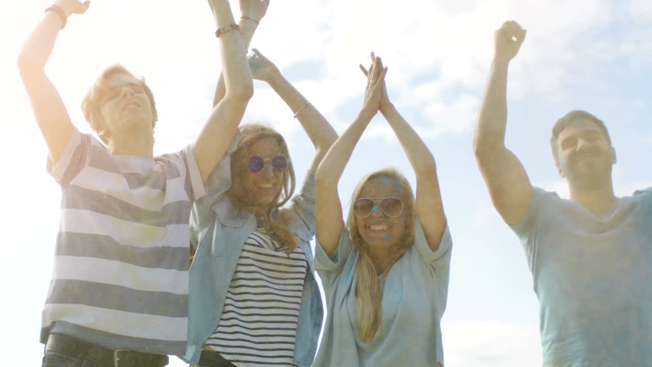 다양한 젊은이들의 다민족 그룹은 홀리 축제를 축하하기 위해 하늘에 다채로운 가루를 던지고 점프합니다. 그들은 이 은 날에 엄청난 재미를 가지고 있습니다.