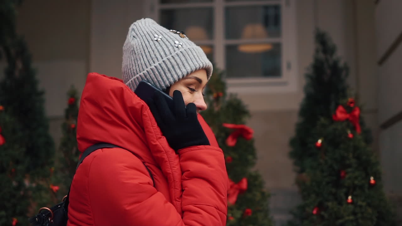 Woman in Red Jacket Talking on Phone Outdoors