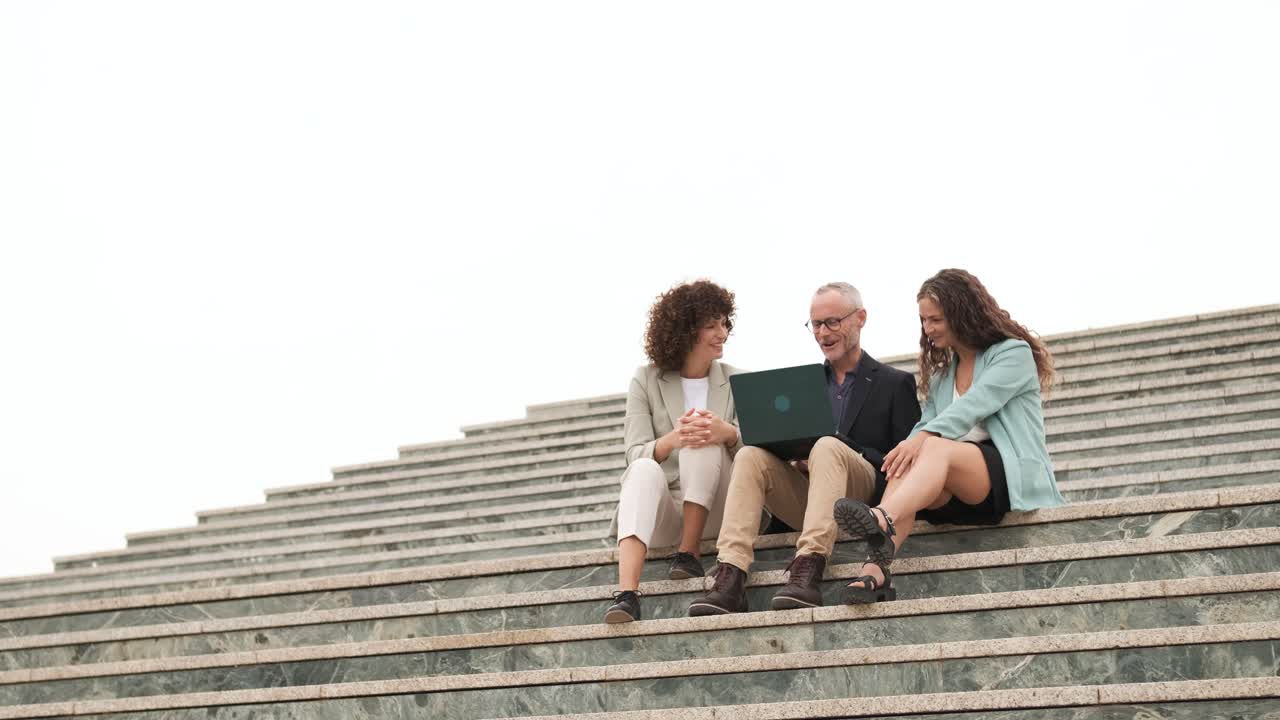 Group of businesspeople with netbook on steps