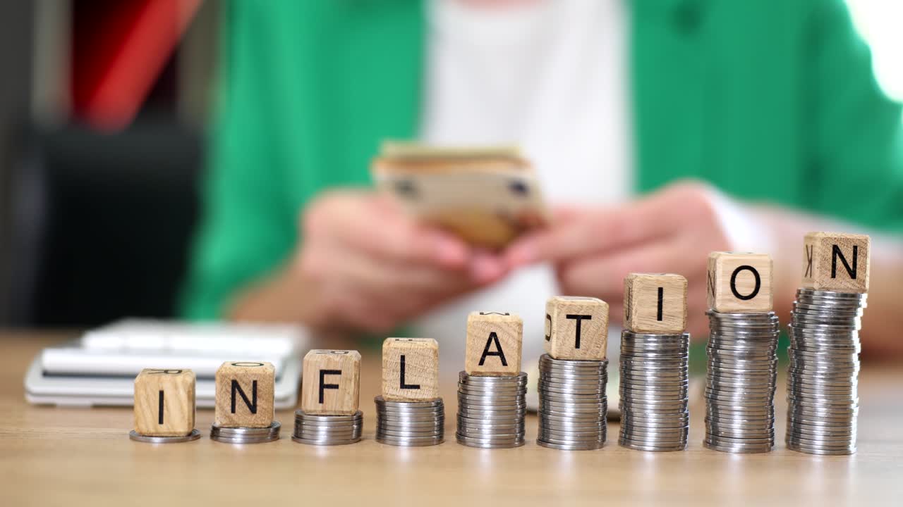 Inflation Concept with Coins and Lettered Wooden Cubes