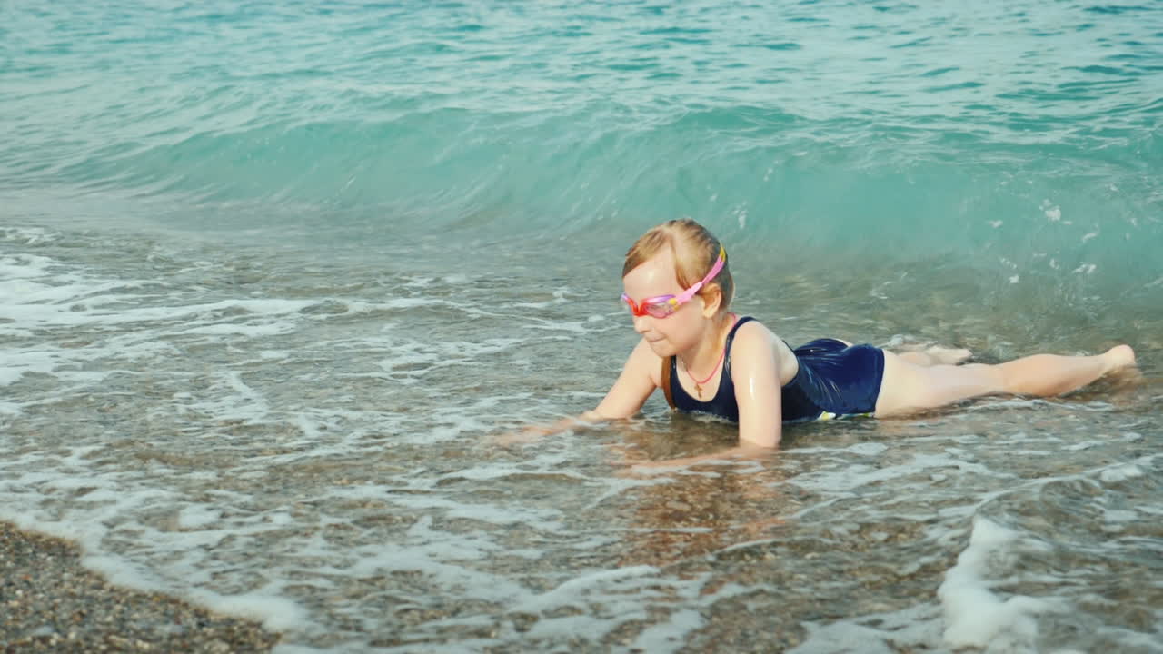 funny girl having fun in the water of the surf rest on the sea concept slow  motion video