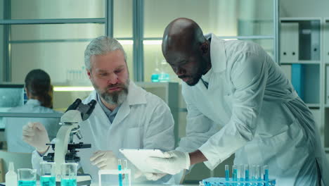 multiethnic colleagues cooperating in laboratory