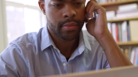 businessman using laptop at desk in busy office shot on r3d