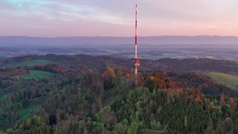 aerial drone view from above the bantiger tv tower near berne on a gorgeous morning with dramatic sunrise colors and lush mountain views