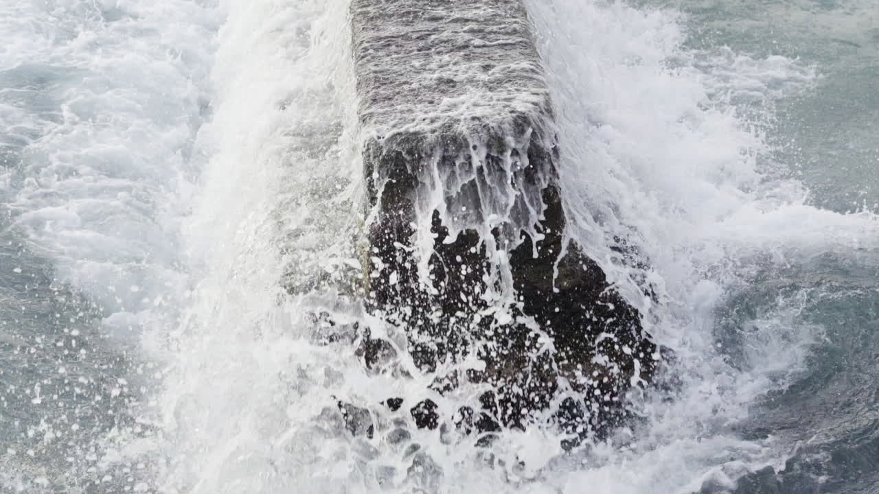 Closeup of ocean water tides hitting concrete pier at Waikiki,Hawaii