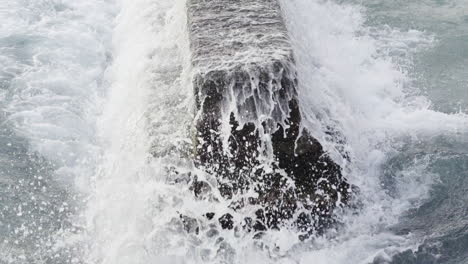 Primer-Plano-De-Las-Mareas-De-Agua-Del-Océano-Golpeando-El-Muelle-De-Hormigón-En-Waikiki,-Hawaii