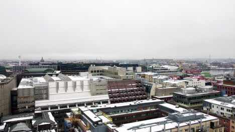 le drone monte, se penche vers le bas pour révéler l'appartement industriel et les bureaux avec de la neige sur les toits le jour nuageux gris