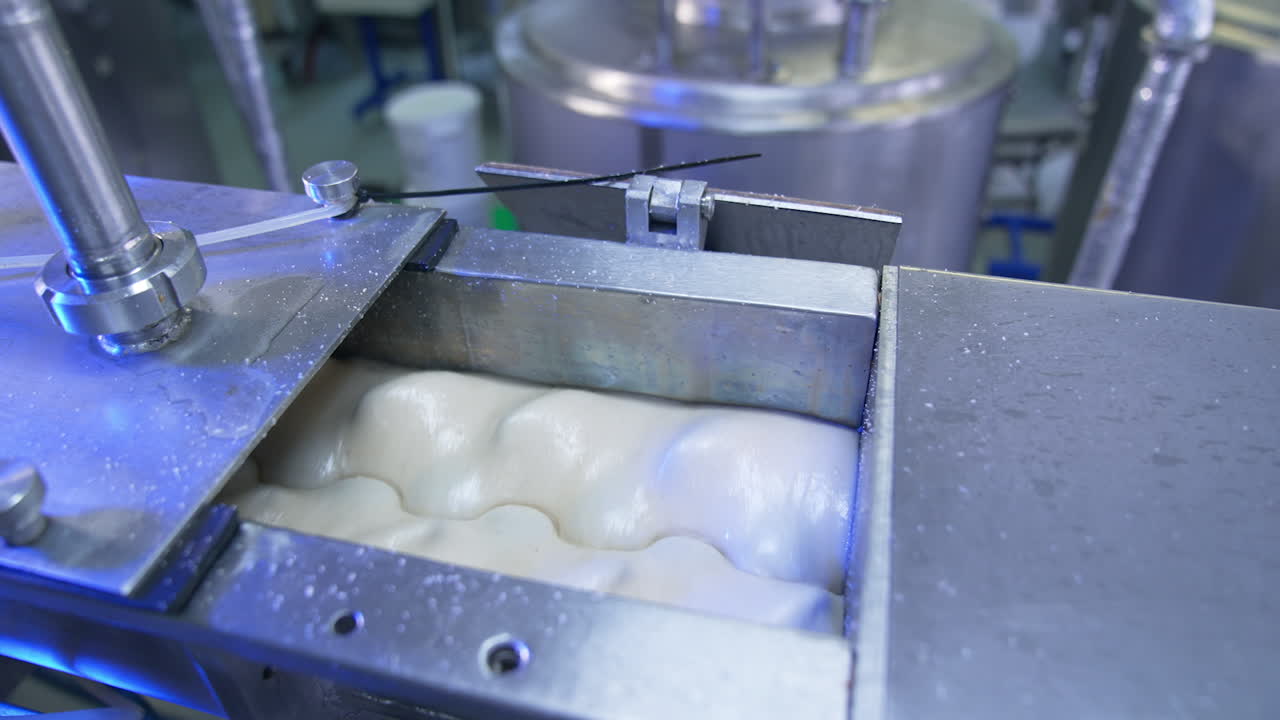 Automatic machine mixing white liquid. Metal tank nozzles rotating condensed milk for future processing. Close up.