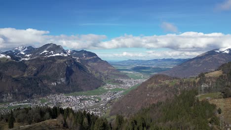 view of the village of in a green valley at the base of the alps