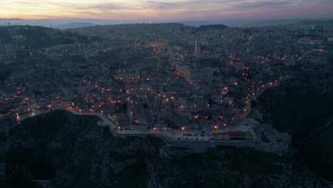 La-Ciudad-Italiana-De-Matera-Después-Del-Atardecer,-Iluminada-Por-Farolas