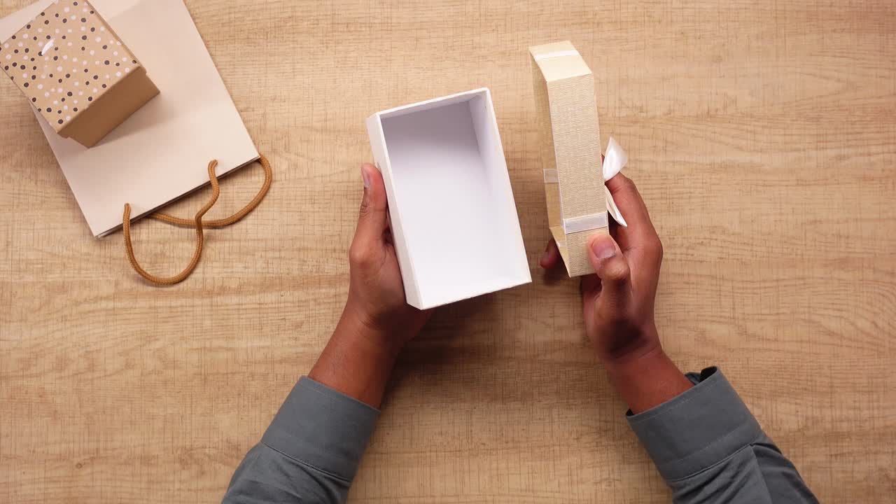 Hands Opening a Thank You Gift Box on Wooden Table