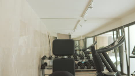 young strong man with face mask lifts weights and exercises in the gym