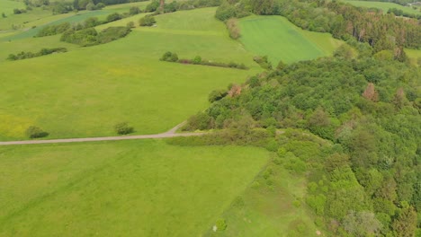 flying over rolling hills with fields in a rural countryside