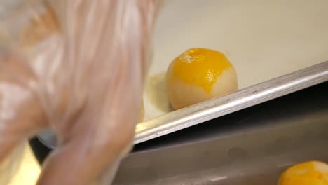 Hand-Put-Baked-Chinese-Pastry-on-Tray,-Close-Up-2