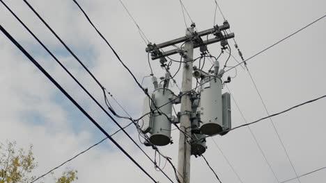 a power line pole with transformers on it. typical of the united states