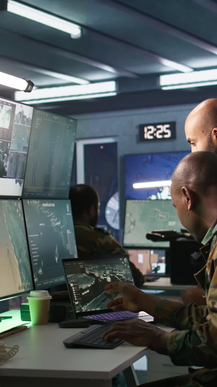 Vertical video Team of army specialists examining data in monitoring room