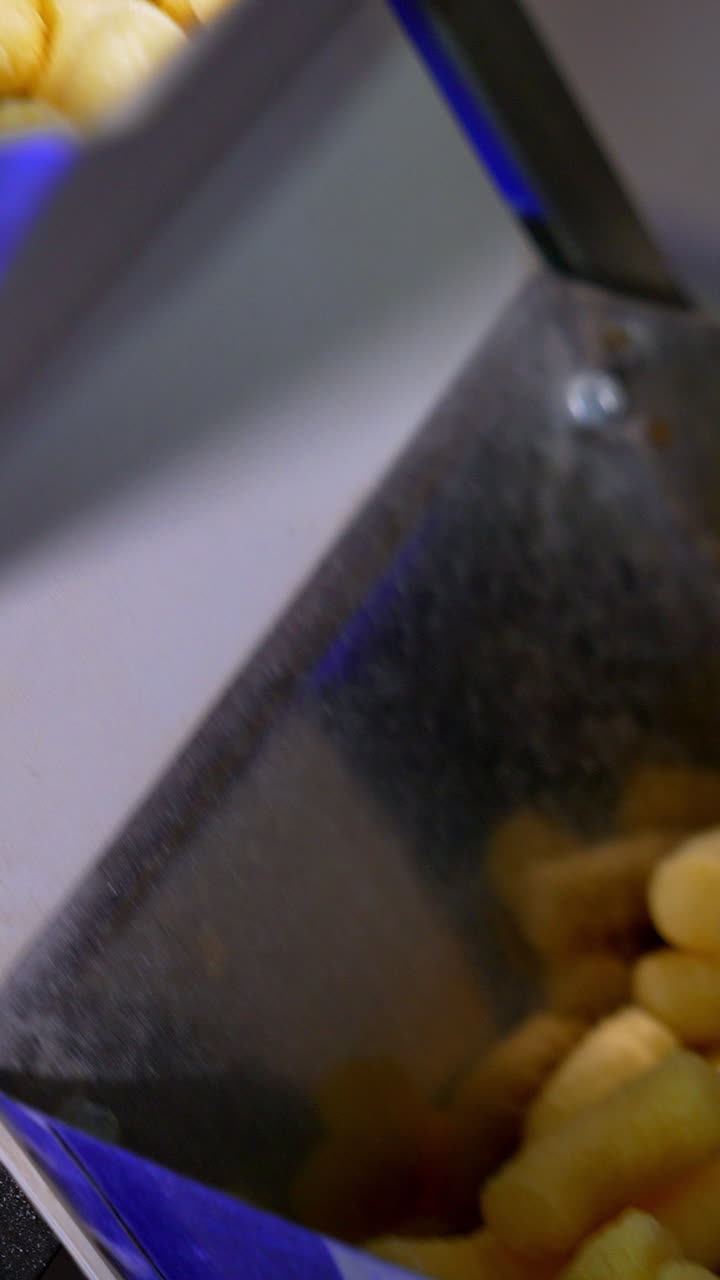 Snacks of corn making for kids. Sticks of corn making in the factory. Vertical video