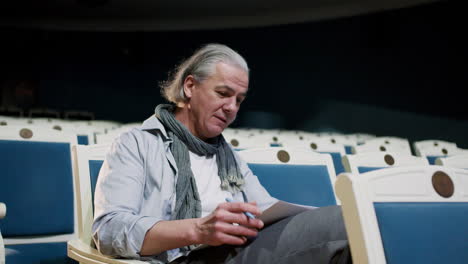 old man sitting on his seat at the teather