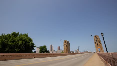 Guardians-of-Transportation-in-Cleveland,-Ohio-on-a-sunny-day-with-fast-cars-driving-by