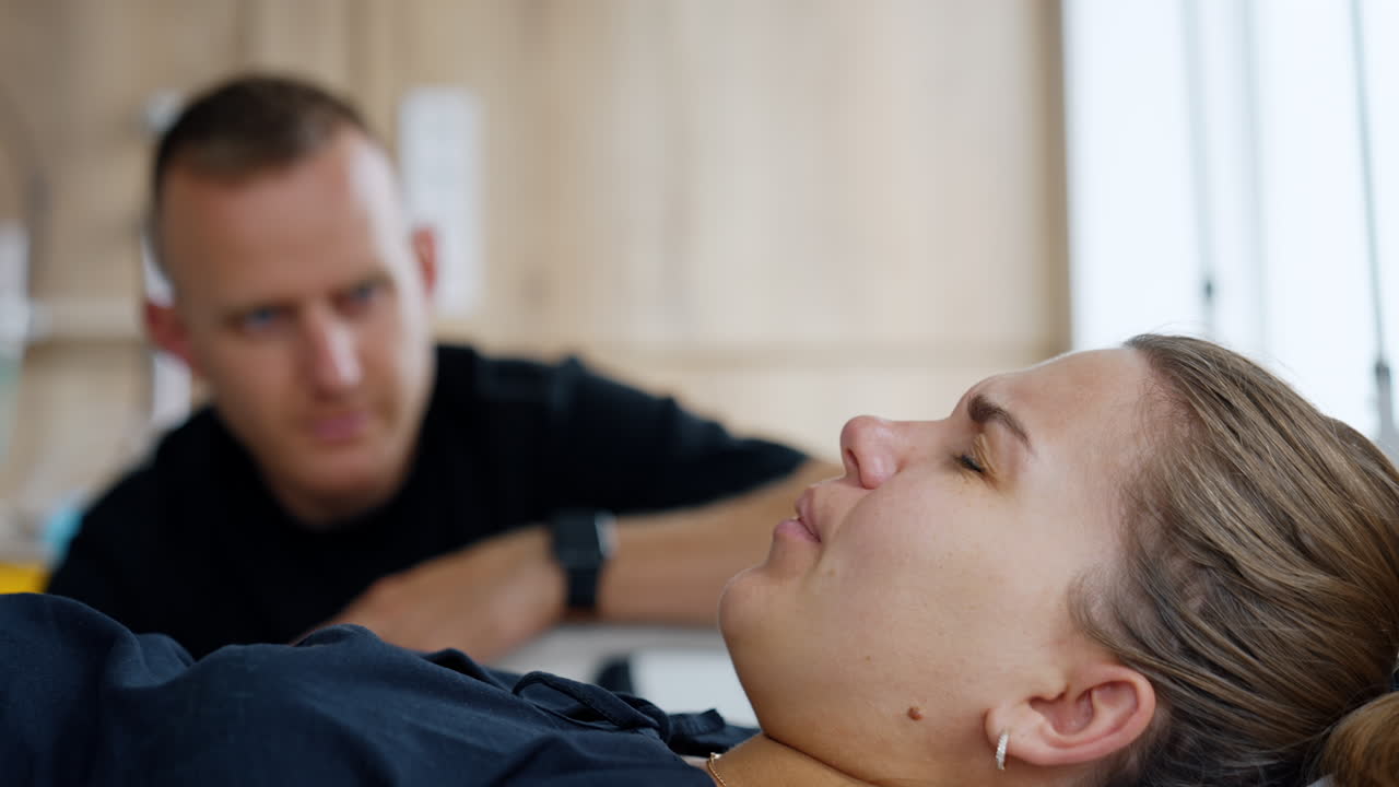 Woman has painful contractions and breathes slowly. Husband sits at her bed looking attentively at wife. Close up.