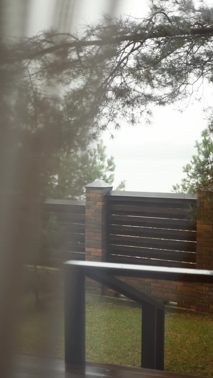 Sumuinen puutarhanäkymä puuaidalla ja puilla