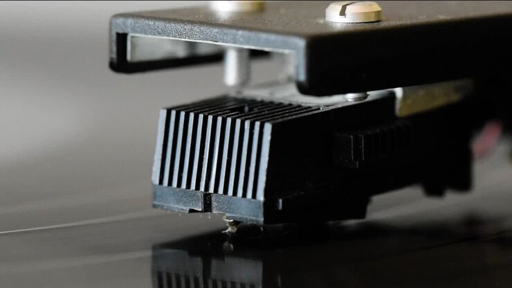 Closeup of a retro-style pickup arm on a vinyl disc