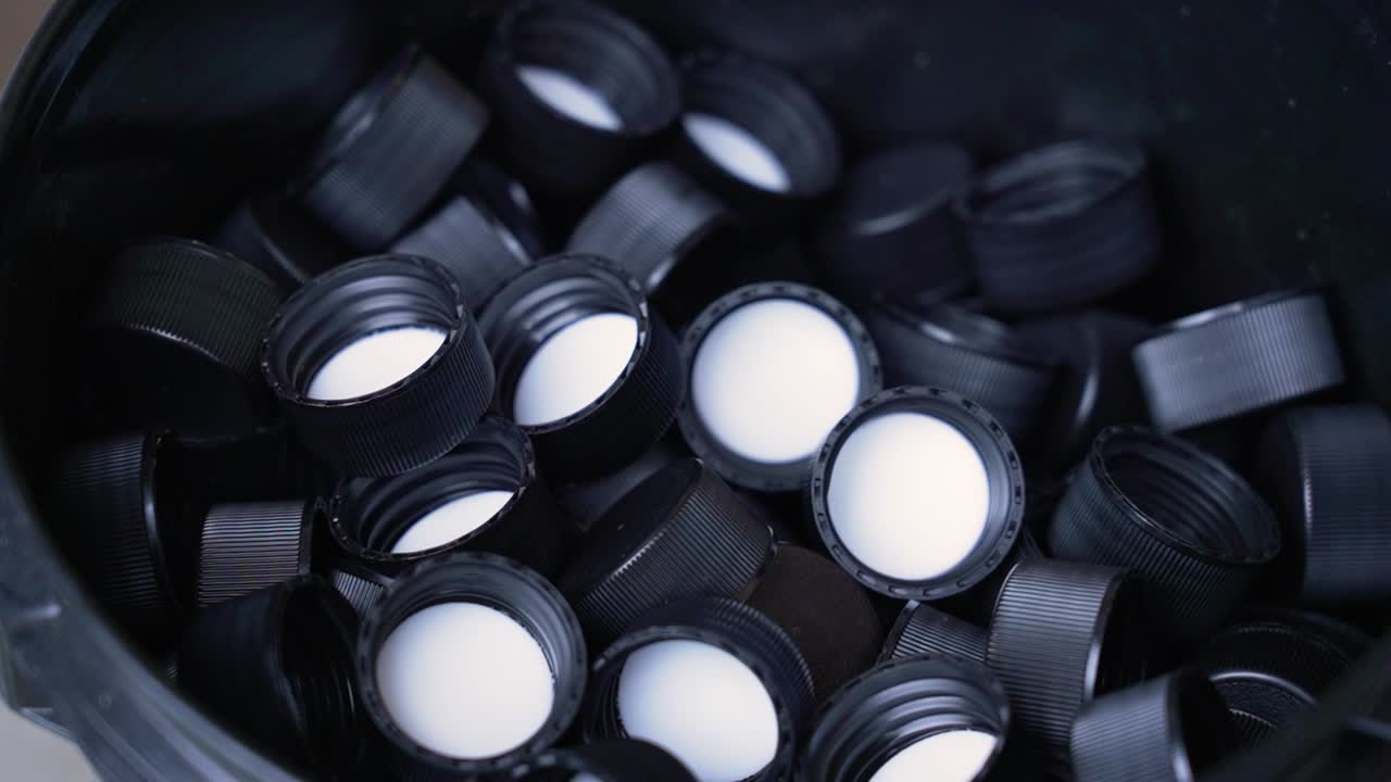 A box filled with black bottle caps