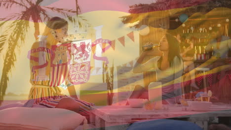 at beach bar, women holding drinks with animation of spanish flag overlay