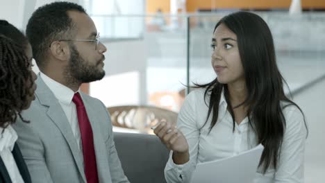 Businesswoman-holding-papers-and-talking-with-colleagues