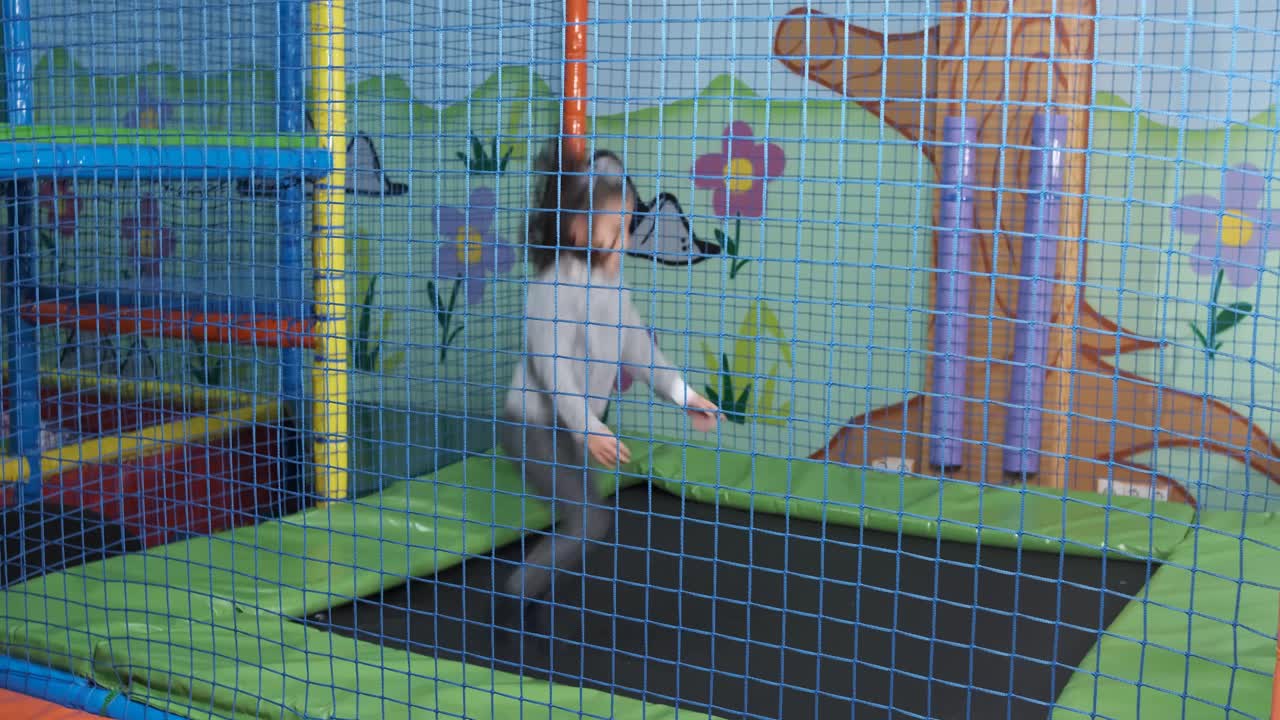 6-year-old girl jumping on the trampoline at the play center