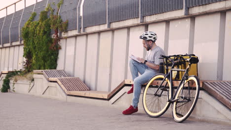 food delivery man waits for the next order reading a book