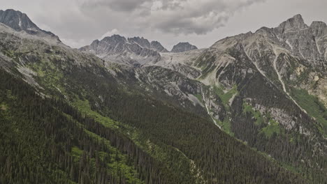 Rogers-Pass-BC-Canada-Aerial-v2-drone-flyover-Glacier-National-Park-capturing-dramatic-mountain-scenery,-with-towering-peaks,-steep-cliffs,-and-dense-forests---Shot-with-Mavic-3-Pro-Cine---July-2023