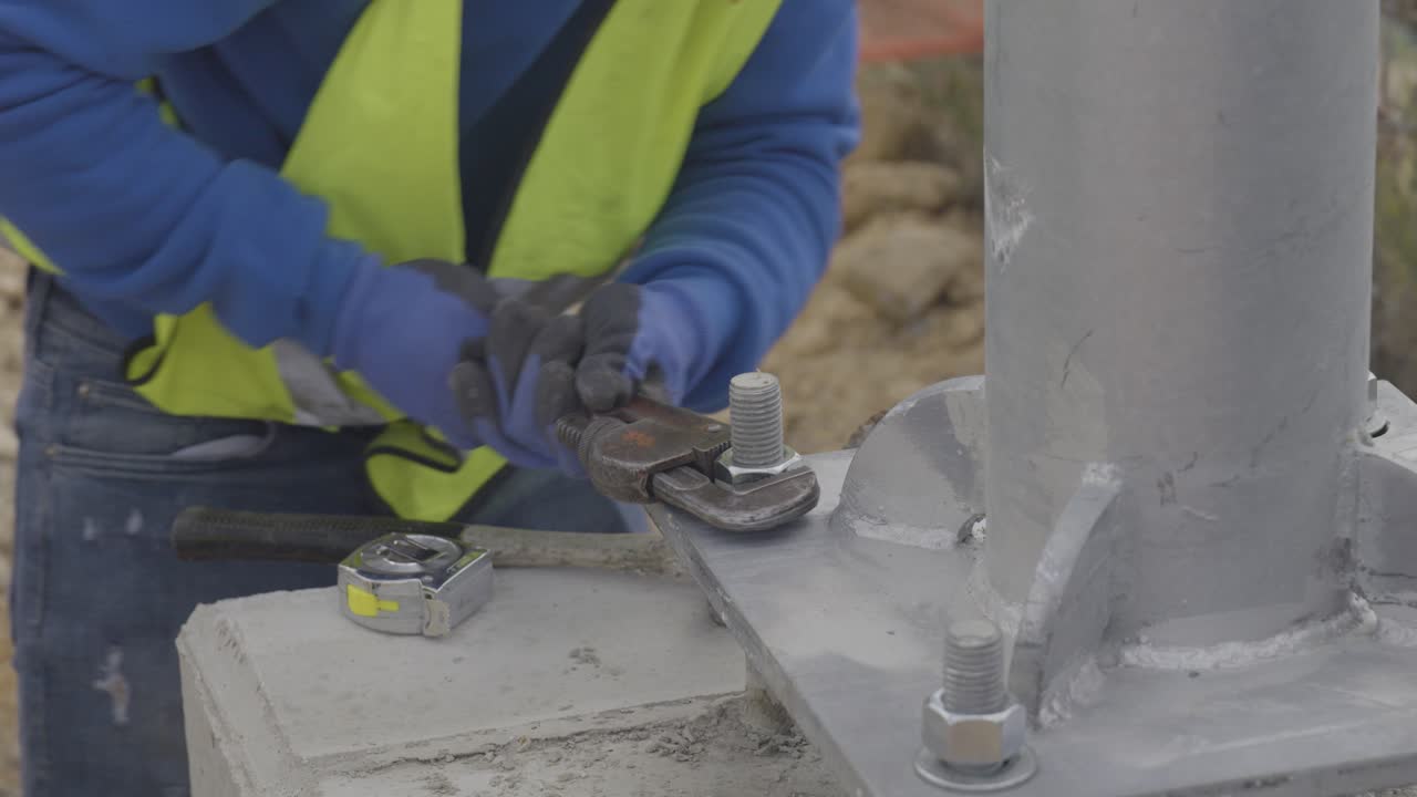 Worker Tightening Bolt with Wrench on Metal Structure at Jobsite