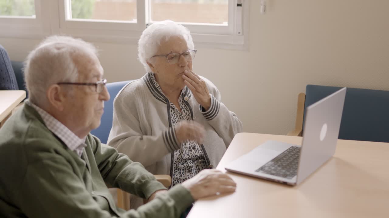 Anziani che effettuano una videochiamata su un portatile in geriatria